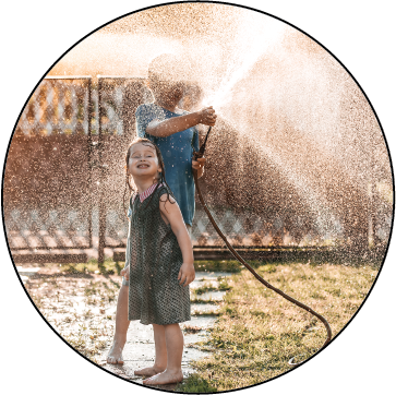 Kids playing in water from hose.